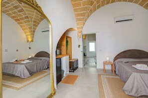 A hotel room with two beds, a mirror, a kitchenette, and a view of the hallway. - Private Oasi With Spa and Pool (Melissano)