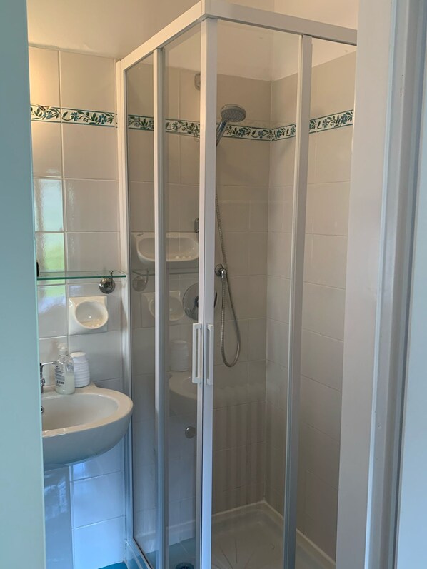 A modern bathroom with a glass-enclosed shower, a sink, and a toilet. - La Turr de Mezz (Nesso)