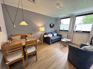 Un salon chaleureux avec une table à manger en bois, un canapé bleu et un fauteuil bleu.