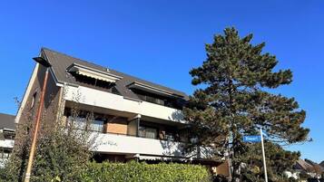 Un edificio residencial de dos plantas con un balcón en el segundo piso.