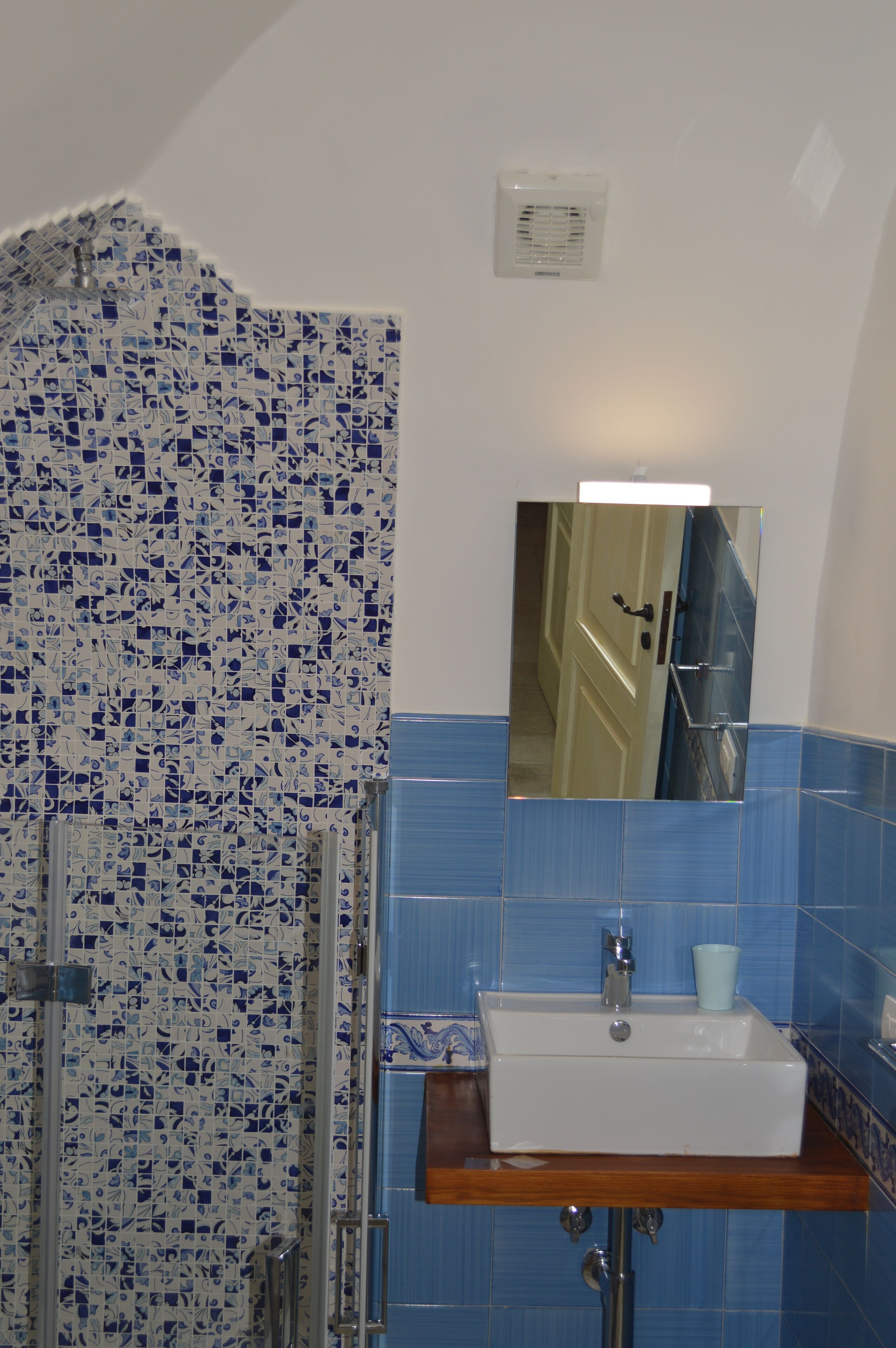A bathroom with a shower, a sink, and a mirror.