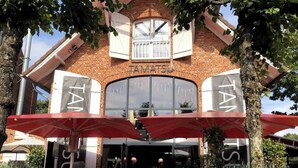 A brick building with large windows and a sign reading 'TAMATSUI.' - Strandhütte direkt am Leuchtturm und Strand in SPO (Sankt Peter-Ording)