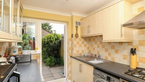 A compact kitchen with a washing machine, a sink, and a stove. - 14 Shorwell (Southampton)