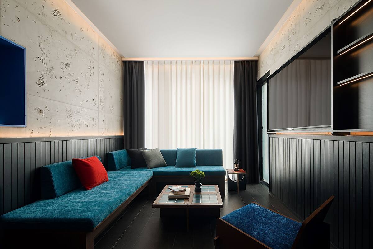 A modern living room with a sectional sofa, a coffee table, and a flat-screen TV.