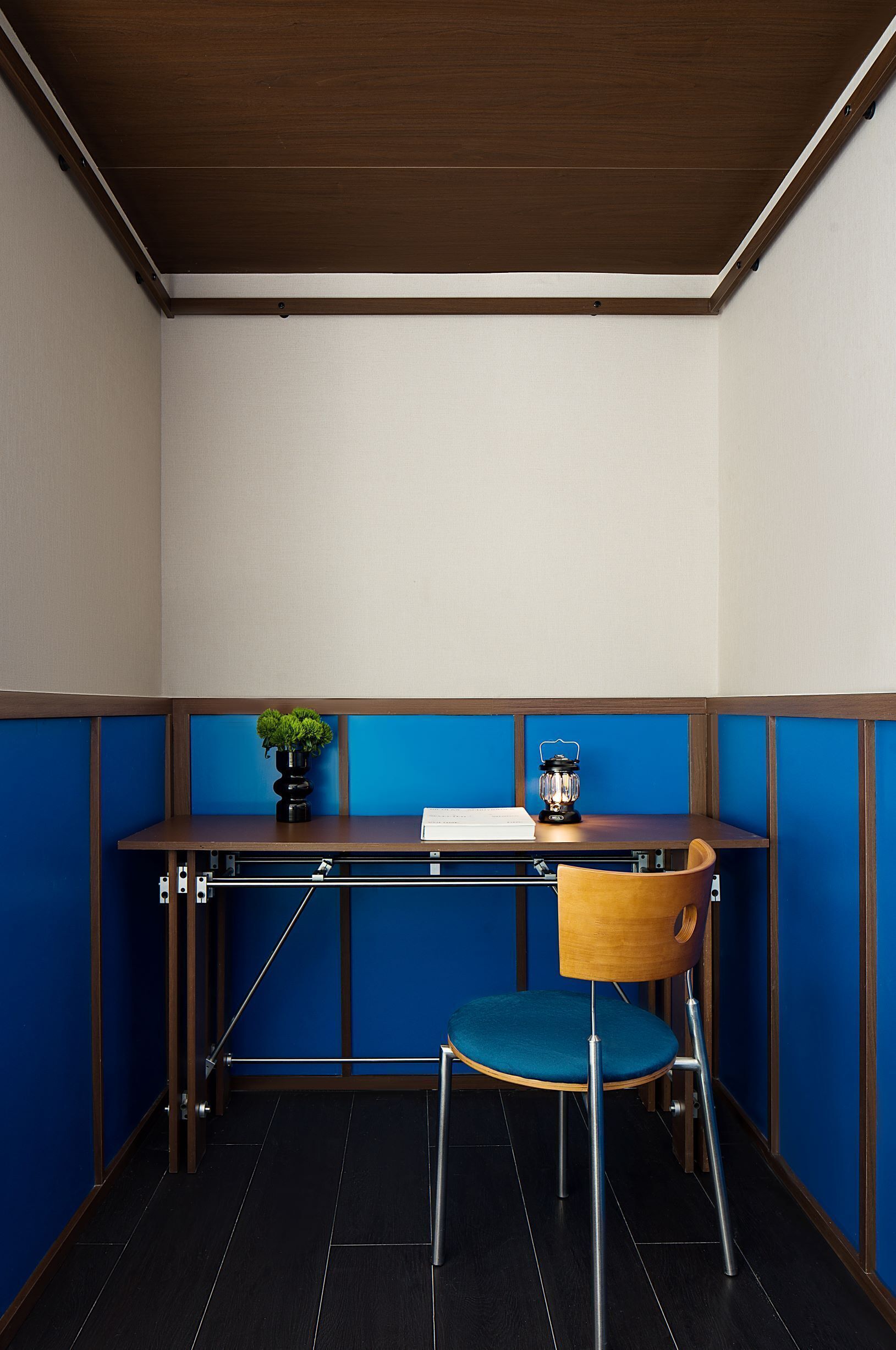 Une pièce d’angle comprenant un bureau, une chaise et une petite plante en pot.