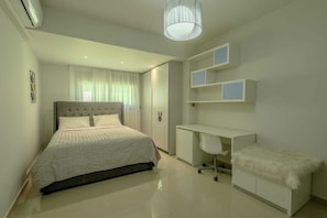 Quarto moderno com cama, escrivaninha e estante.