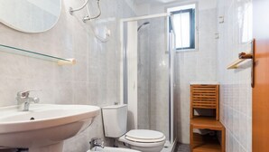 Une salle de bain équipée d’un lavabo, de toilettes, d’un bidet et d’une douche.