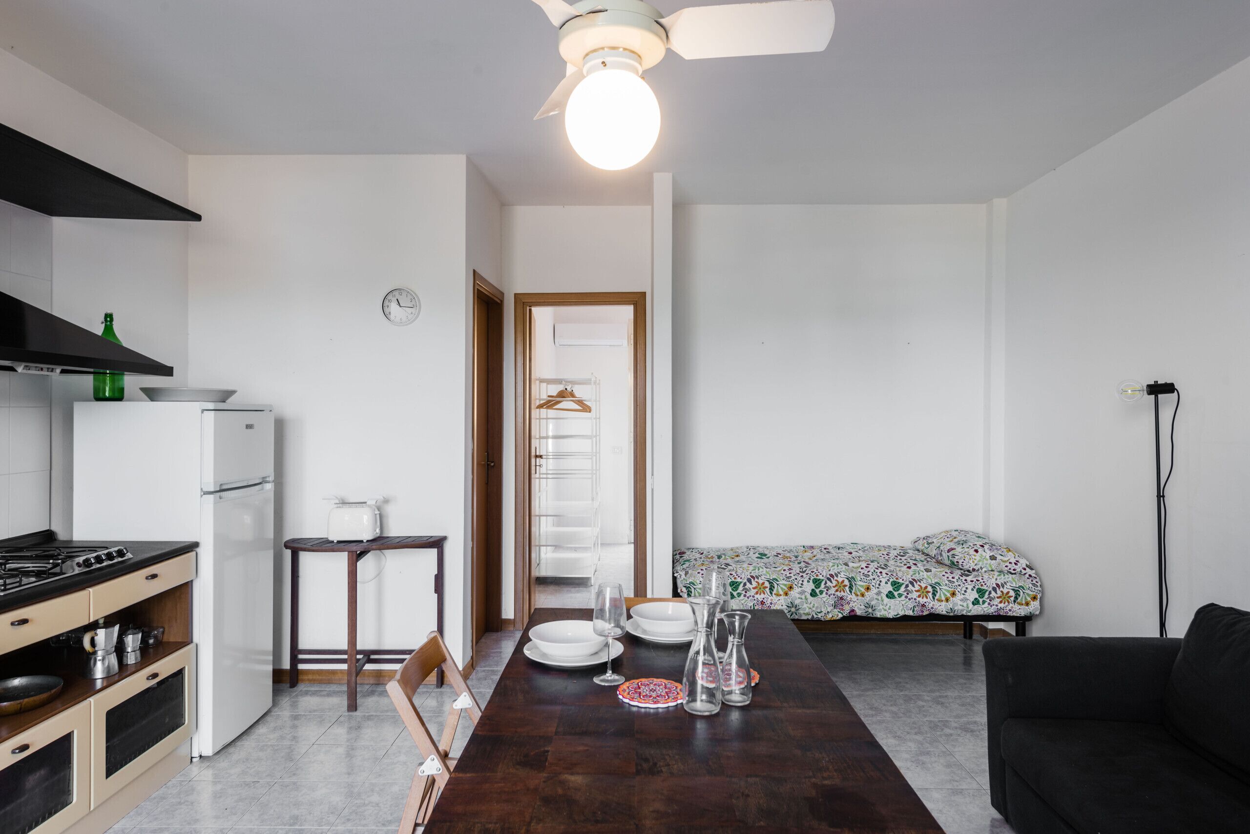 A compact kitchen with a stove, refrigerator, and dining table set for four.