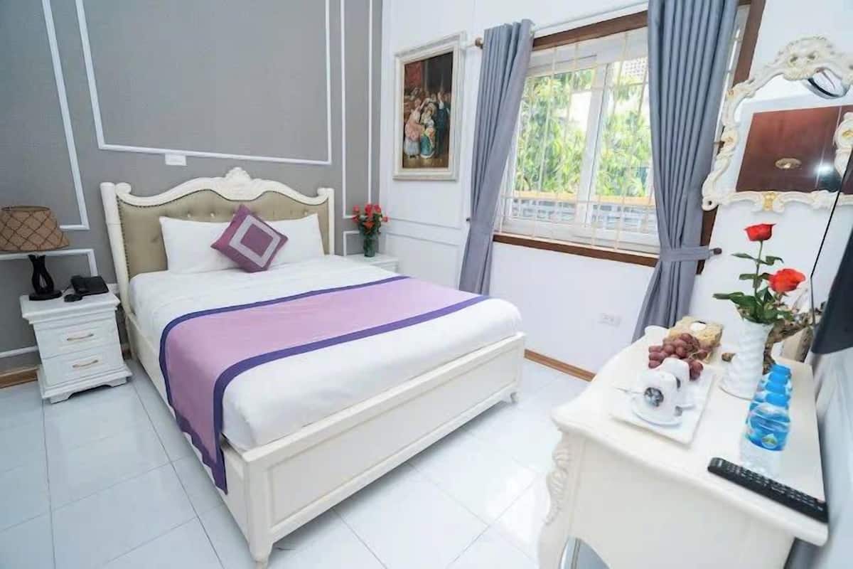 Un dormitorio ordenado con cama, mesita de noche y cómoda.