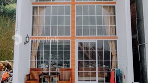 Ein modernes Gebäude mit einer großen Glasfassade, Holzbank-Außenbereich und einer Ziegelbasis.