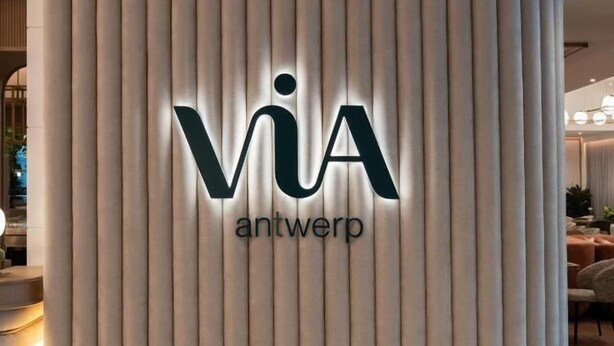 Un'area reception caratterizzata da pannelli verticali e insegna illuminata 'via antwerp'.