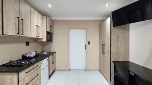 Una cocina con armarios de madera, microondas, fregadero y estufa.