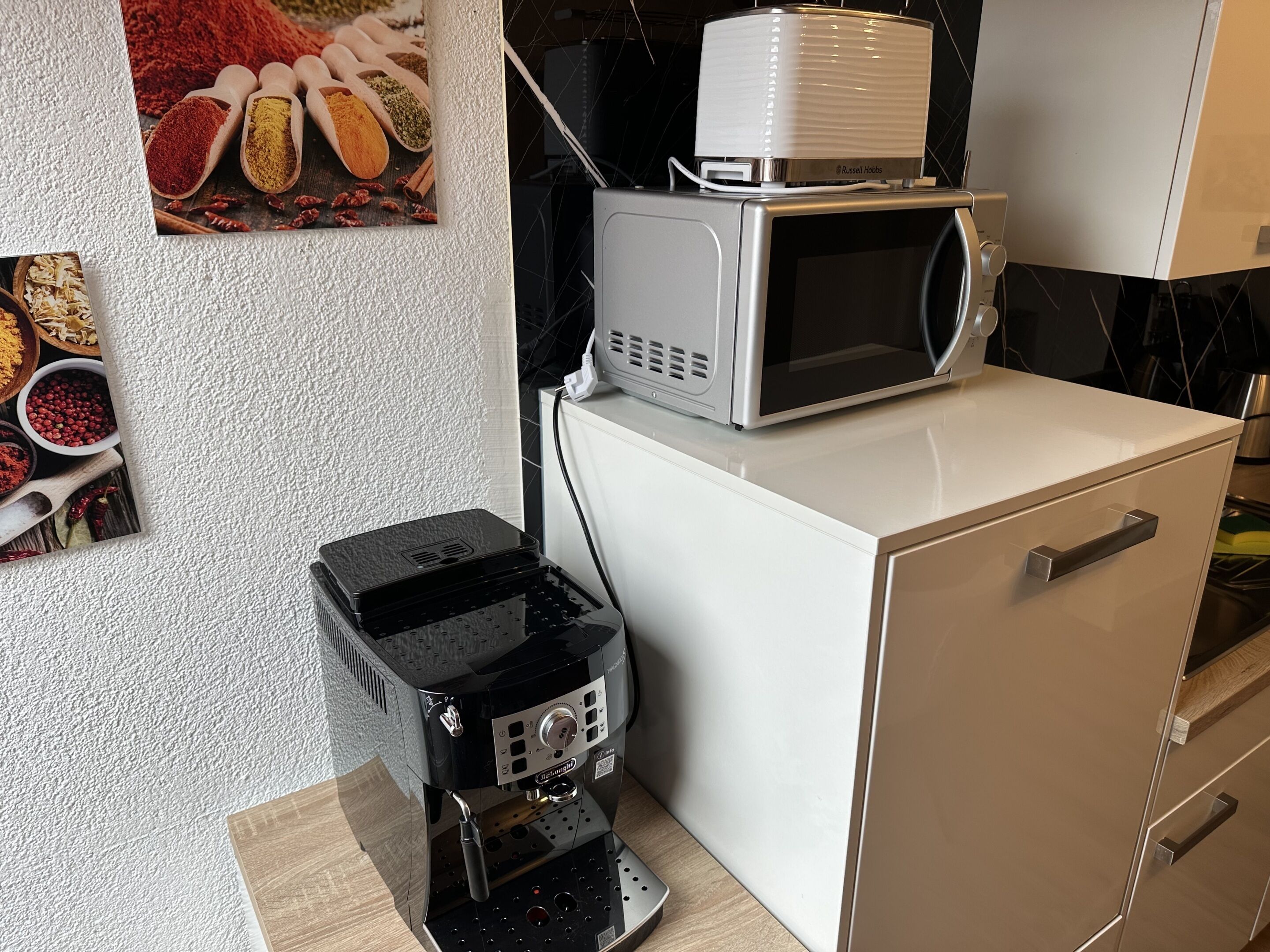 Une cuisine équipée d’une machine à café, d’un four à micro-ondes et d’un petit réfrigérateur.
