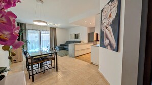 Een moderne woonkamer met een eettafel, bank en keukenhoek.