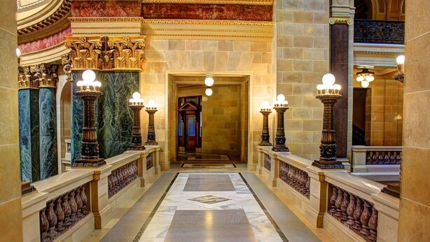 A grand hallway with marble flooring, ornate columns, and wall sconces. - Ech Jarek XD - H5 (Floresville)