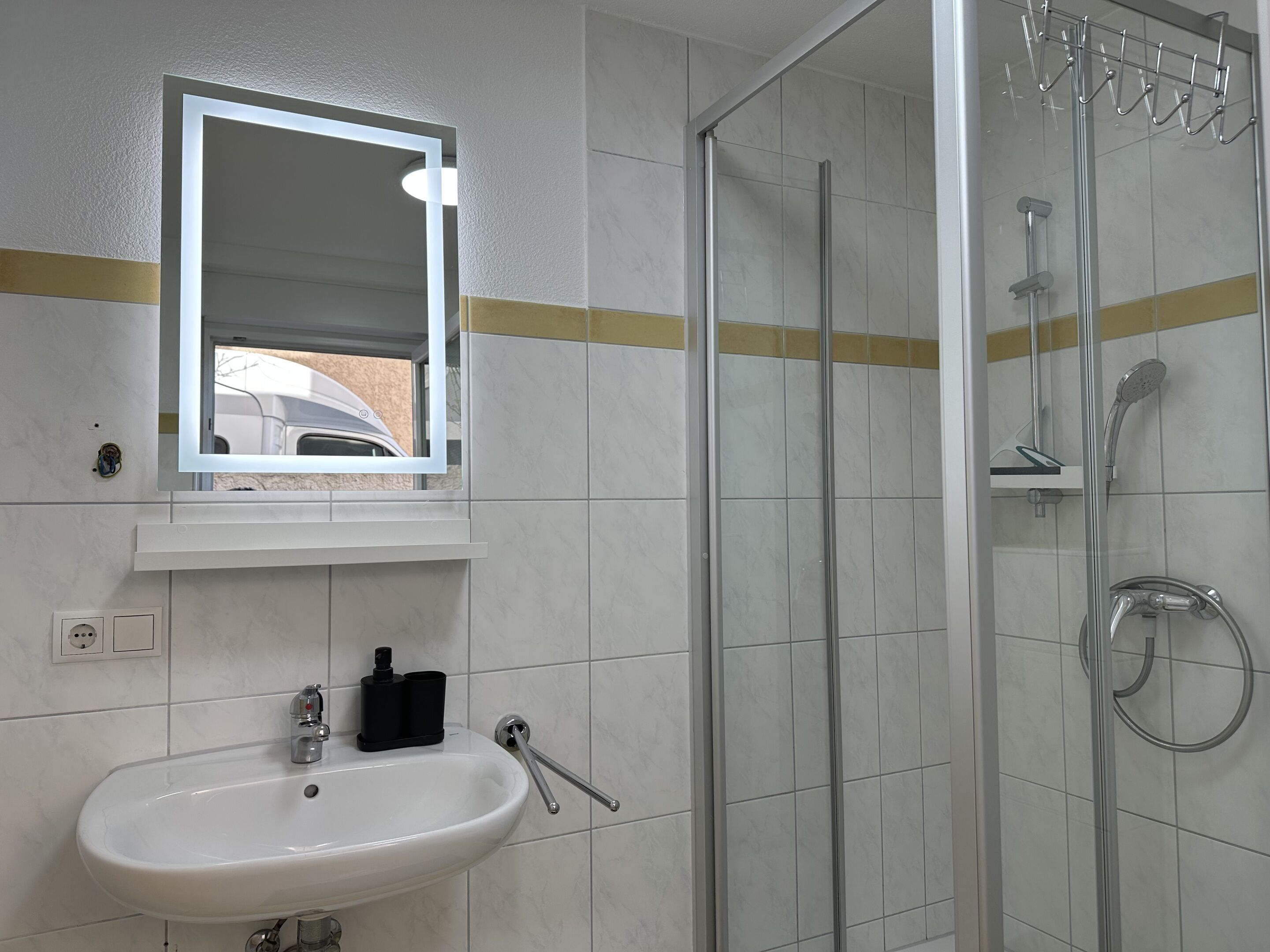 Une salle de bain avec un lavabo, un miroir et une douche.