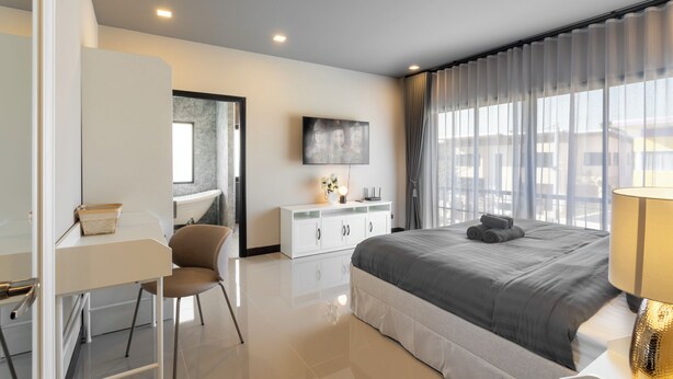 Un dormitorio moderno con una cama grande, un escritorio y una silla.