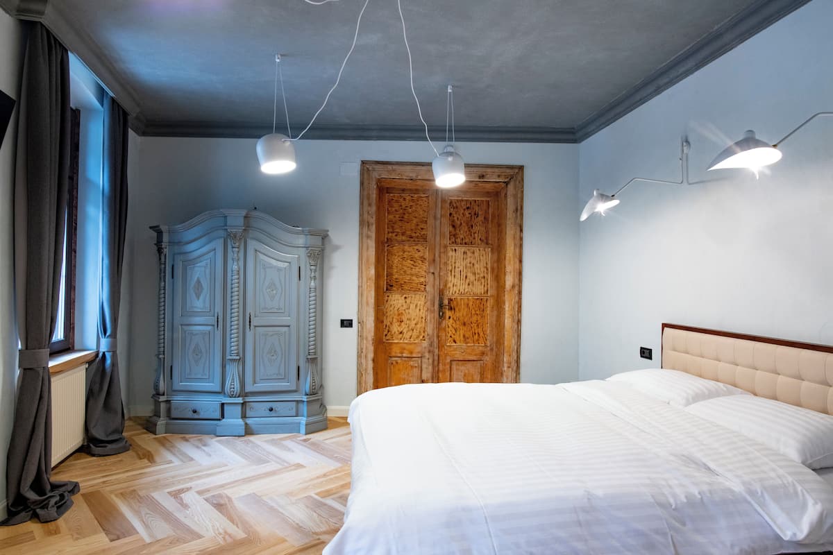 Un dormitorio con una cama grande, un armario y una puerta de madera.