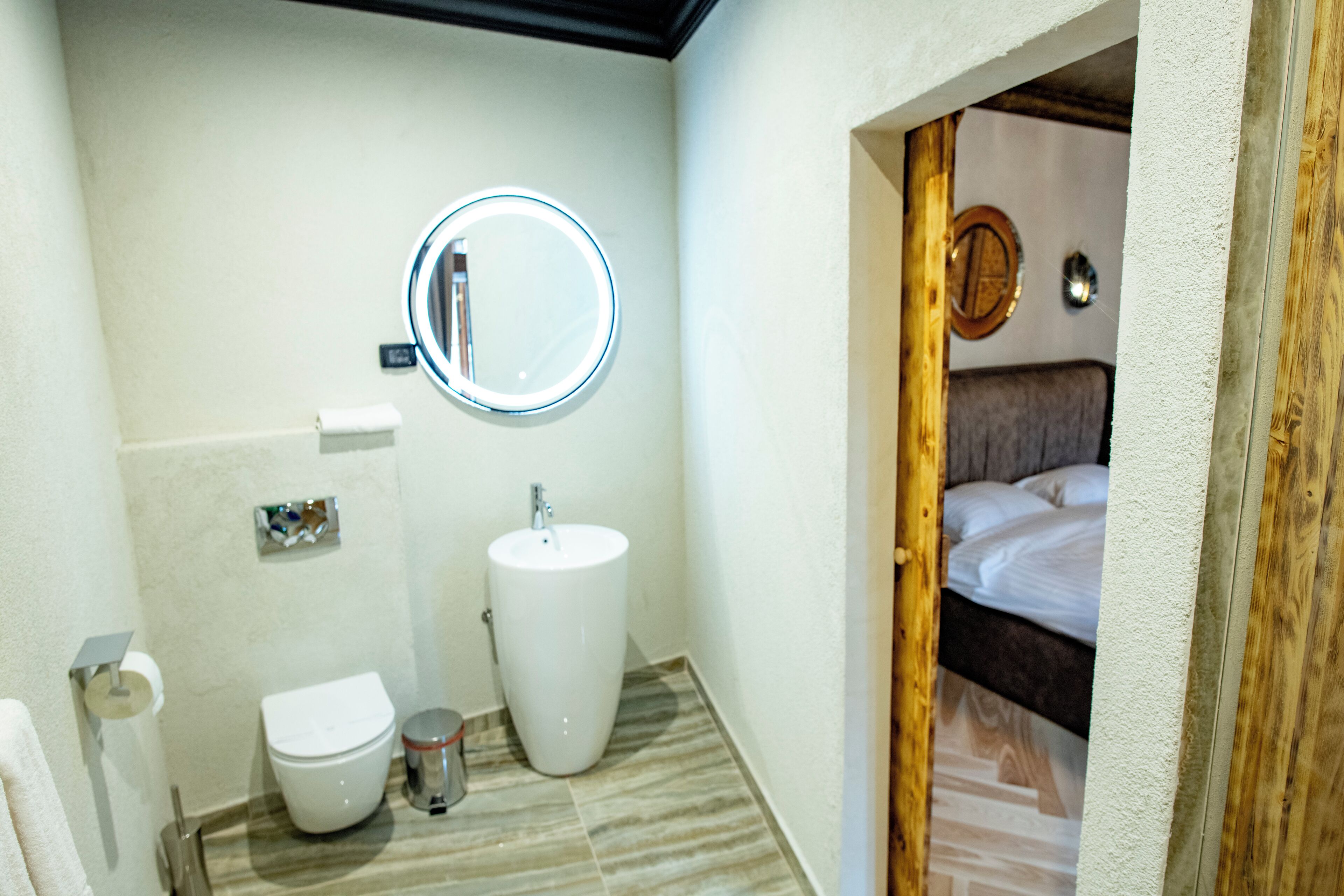 A bathroom with a toilet, sink, and mirror.