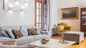 A modern living room with a grey sofa, a yellow armchair, a grey ottoman, and a white coffee table.