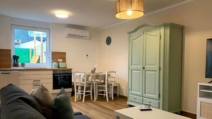 Un salon moderne comprenant un canapé, une table à manger et un coin cuisine avec une fenêtre.