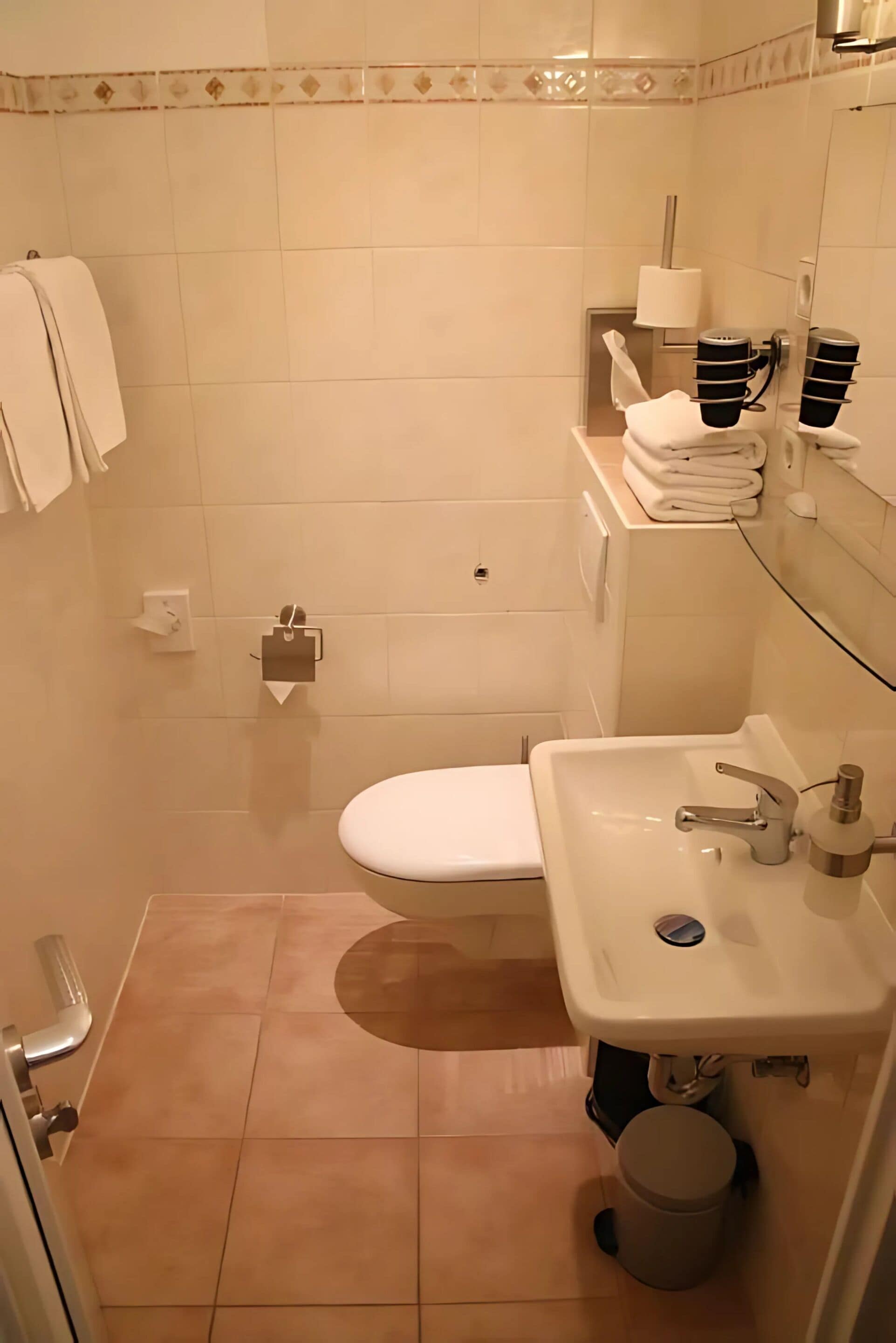 Une salle de bain avec des toilettes, un lavabo et un miroir.