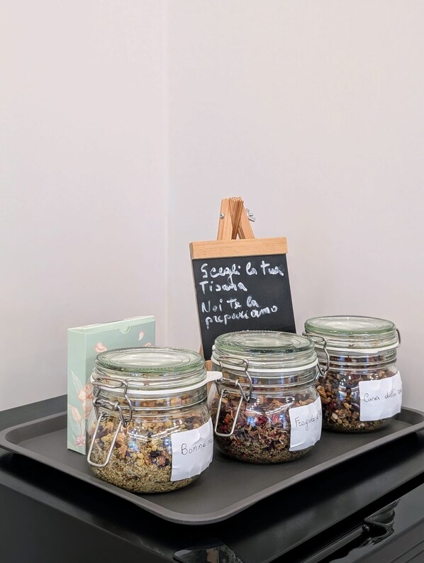 Four glass jars with labels on a black tray, a chalkboard sign, and a green card. - B&B IL GLICINE (Coperchia)