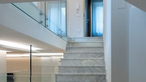 A modern staircase with glass railings leading to a second floor. - B&B IL GLICINE (Coperchia)