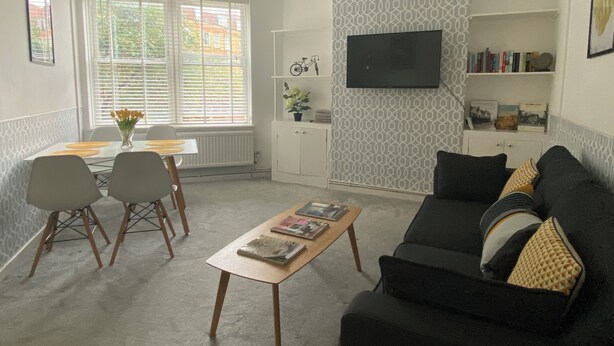 Una sala de estar con sofá, una mesa de centro y un comedor con sillas y una mesa.