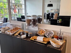 Un bufé de desayuno con diversas opciones de alimentos y acompañamientos.