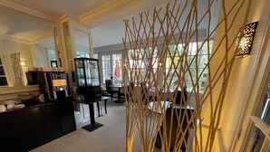 Eine moderne Hotelhalle mit einer Kaffeebar, einer Sitzecke und einer dekorativen Holzkonstruktion.