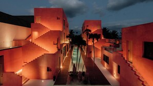 Un hôtel moderne doté d’une piscine centrale, de plusieurs étages et d’une décoration aux couleurs chaudes.