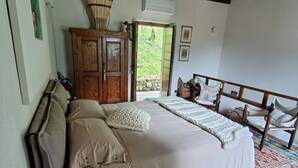 A bedroom with a large bed, wooden headboard, and a rustic ceiling. - 1 bedroom private vacation home in canzo (Canzo)