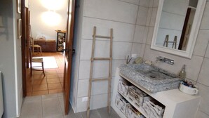 A bathroom with a tiled floor, a wooden ladder, a sink with a marble countertop, and a mirror above it. - 1 bedroom private vacation home in canzo (Canzo)