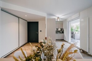 Un intérieur moderne avec un couloir menant à une cuisine et à un coin repas.