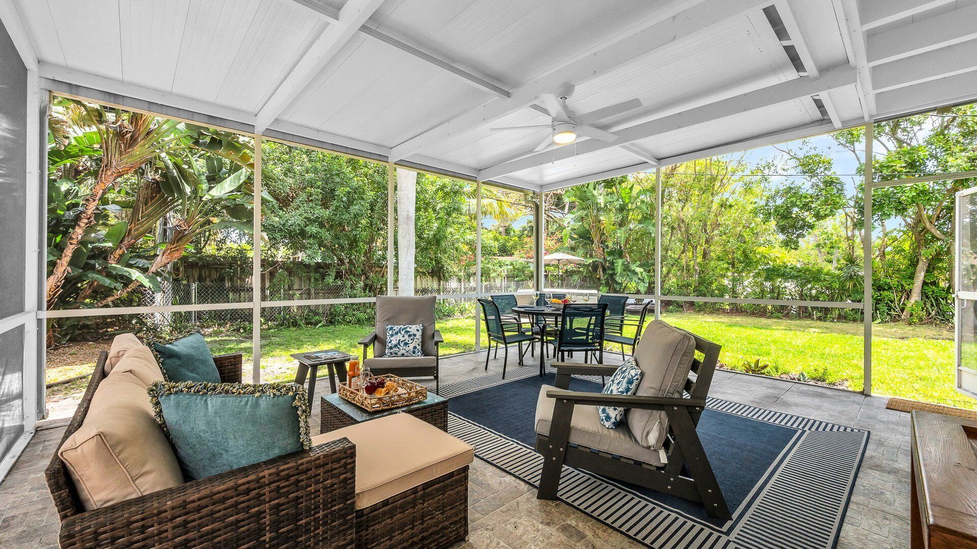 A covered patio with outdoor furniture, a dining table, and chairs.