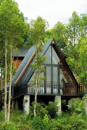 A modern house with a sloped roof, large glass windows, and a balcony. - La Vela Legacy Resort (Hue)