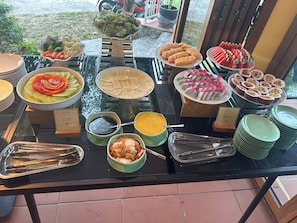 A buffet table with various dishes and condiments.