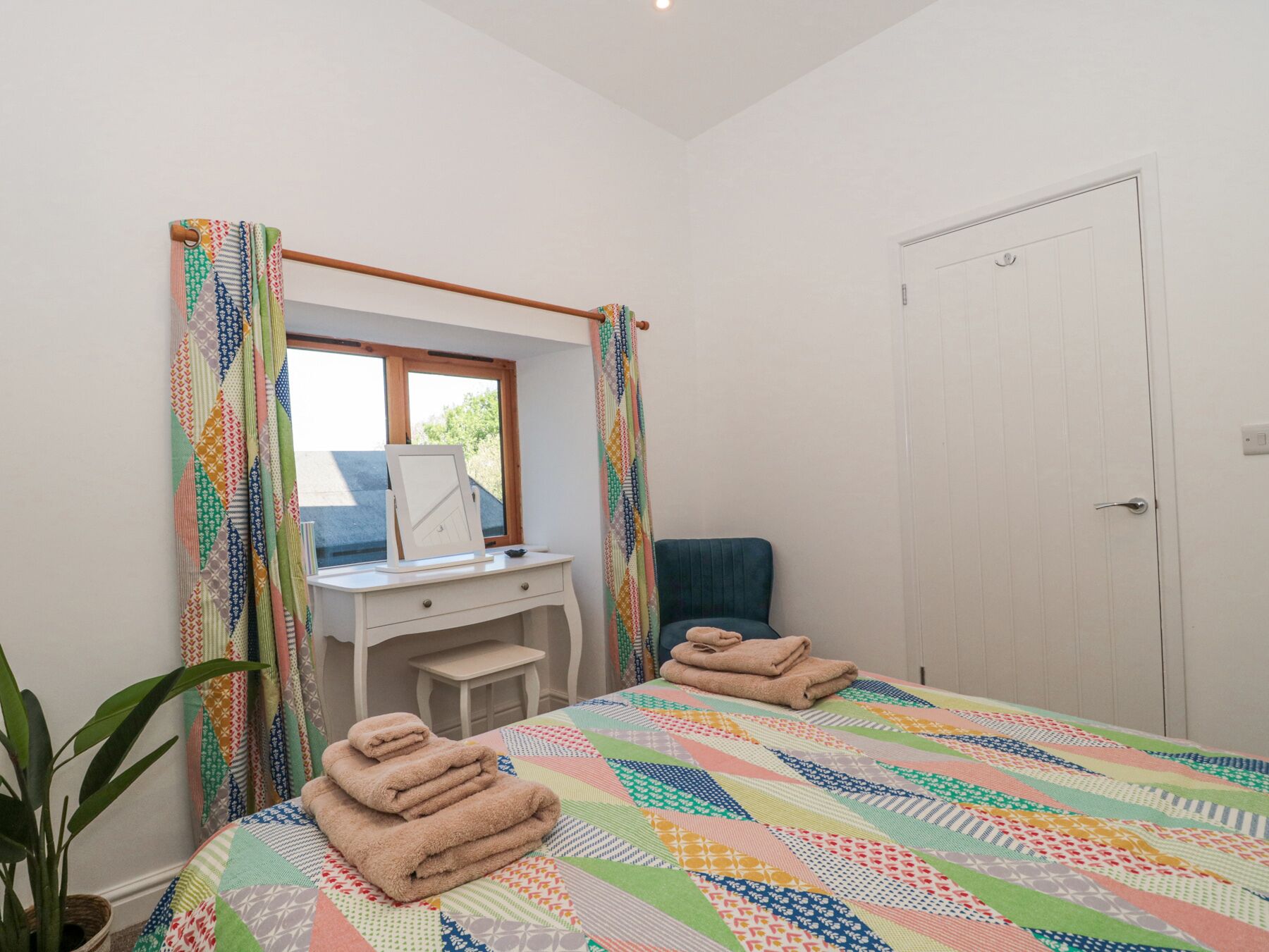 Ein Schlafzimmer mit einem Bett, einem Schreibtisch, einem Stuhl und einer Tür.