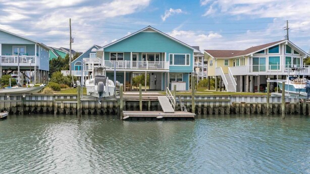 Une propriété située au bord de l’eau, comprenant plusieurs maisons, des quais et des bateaux.