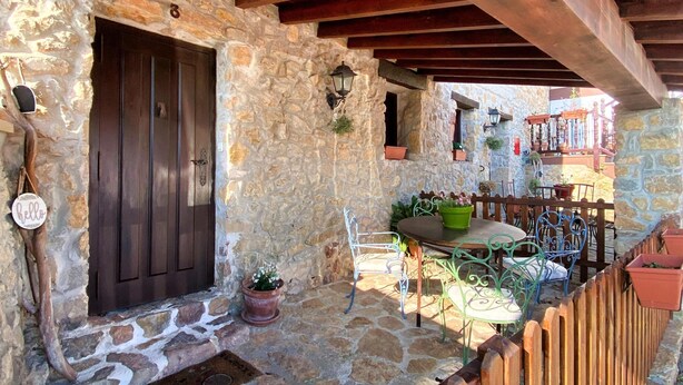 A rustic stone building with a wooden door, a stone wall, and a wooden fence. - 2 bedroom apartment in the historic center of Isla, close to the beach. (Isla)