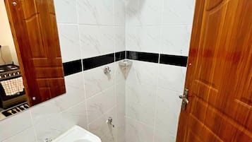 Chuveiro, toalhas de banho, sabonete, papel higiênico