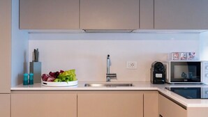 Een moderne keuken met een roestvrijstalen spoelbak, een magnetron en een waterkoker.