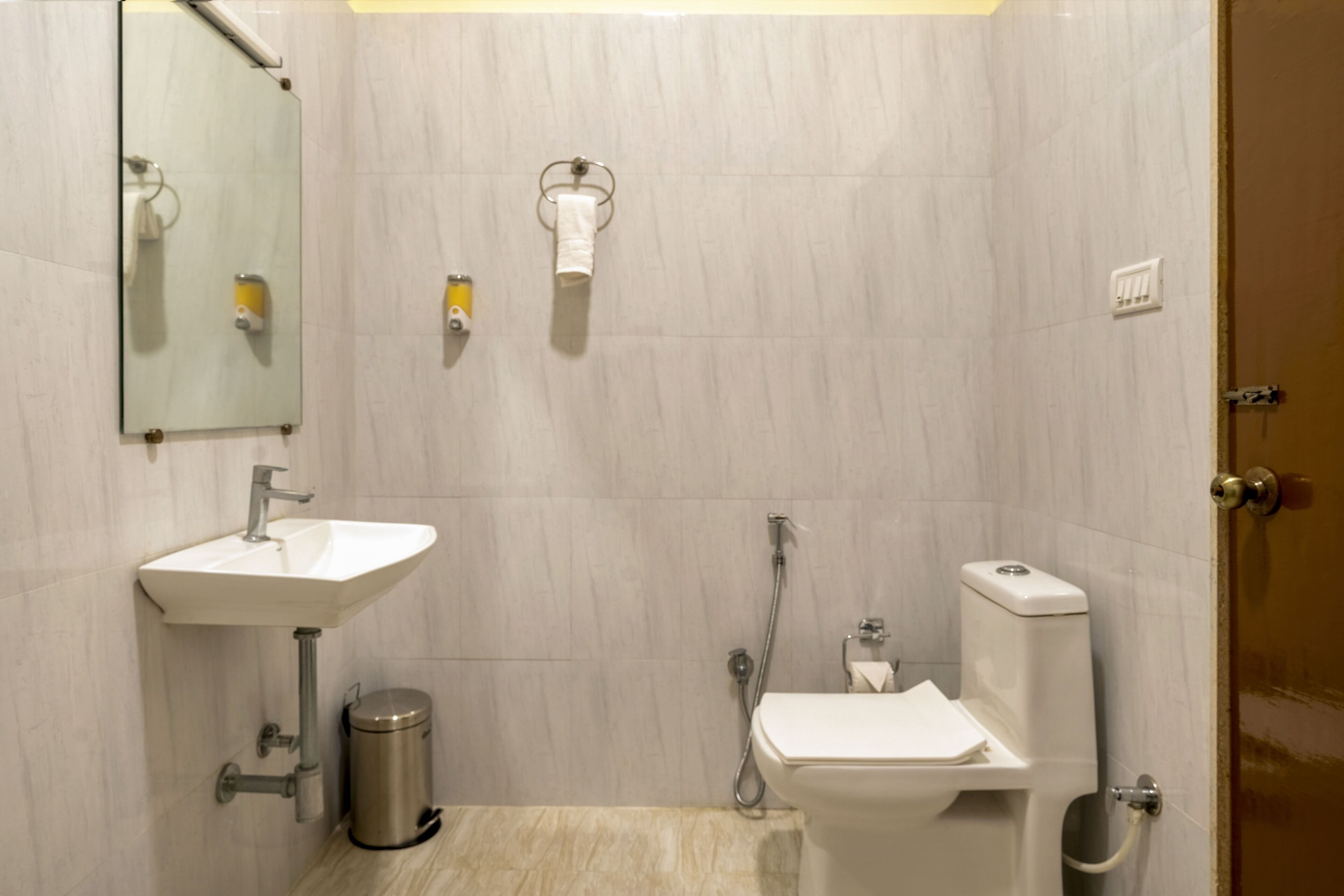 A small, modern bathroom with a sink, toilet, and shower.