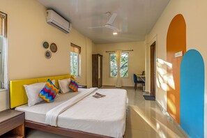 A hotel room with a bed, a desk, and a chair. - goSTOPS Alibaug (Alibag)