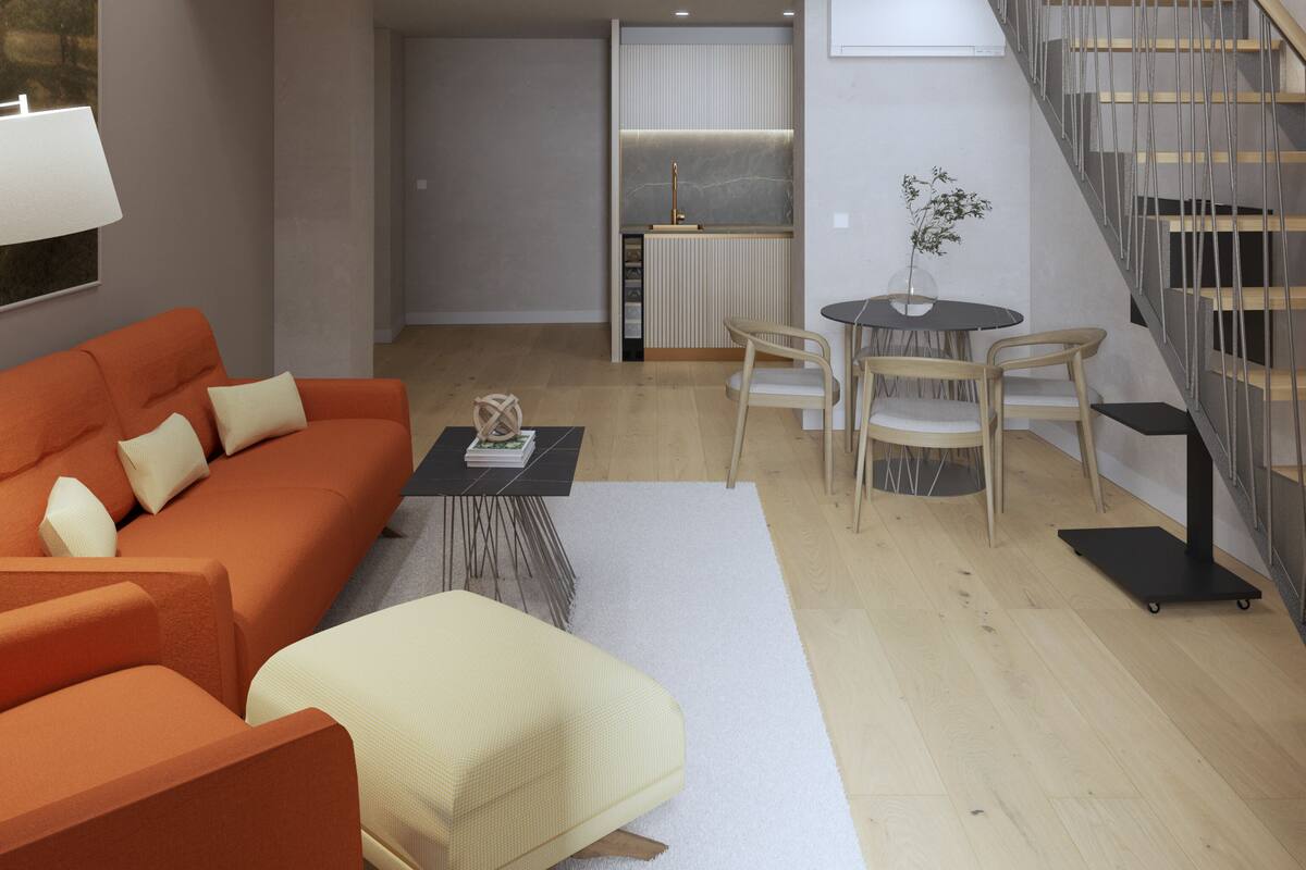 Una sala moderna con sofá, mesa de centro y comedor con sillas. Una escalera conduce a un nivel superior.