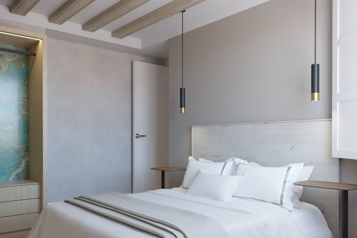 Un dormitorio moderno con una cama grande, mesitas de noche e iluminación colgante.