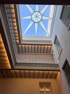 A skylight with a geometric design, a wooden balcony railing, and a modern architectural style. - Torre Camelia (Cádiz)