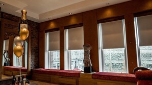 A modern interior with large windows, a glass table with bottles, and a red bench. - Infinity Partypadsliverpool Hen and Stag Welcome (Liverpool)