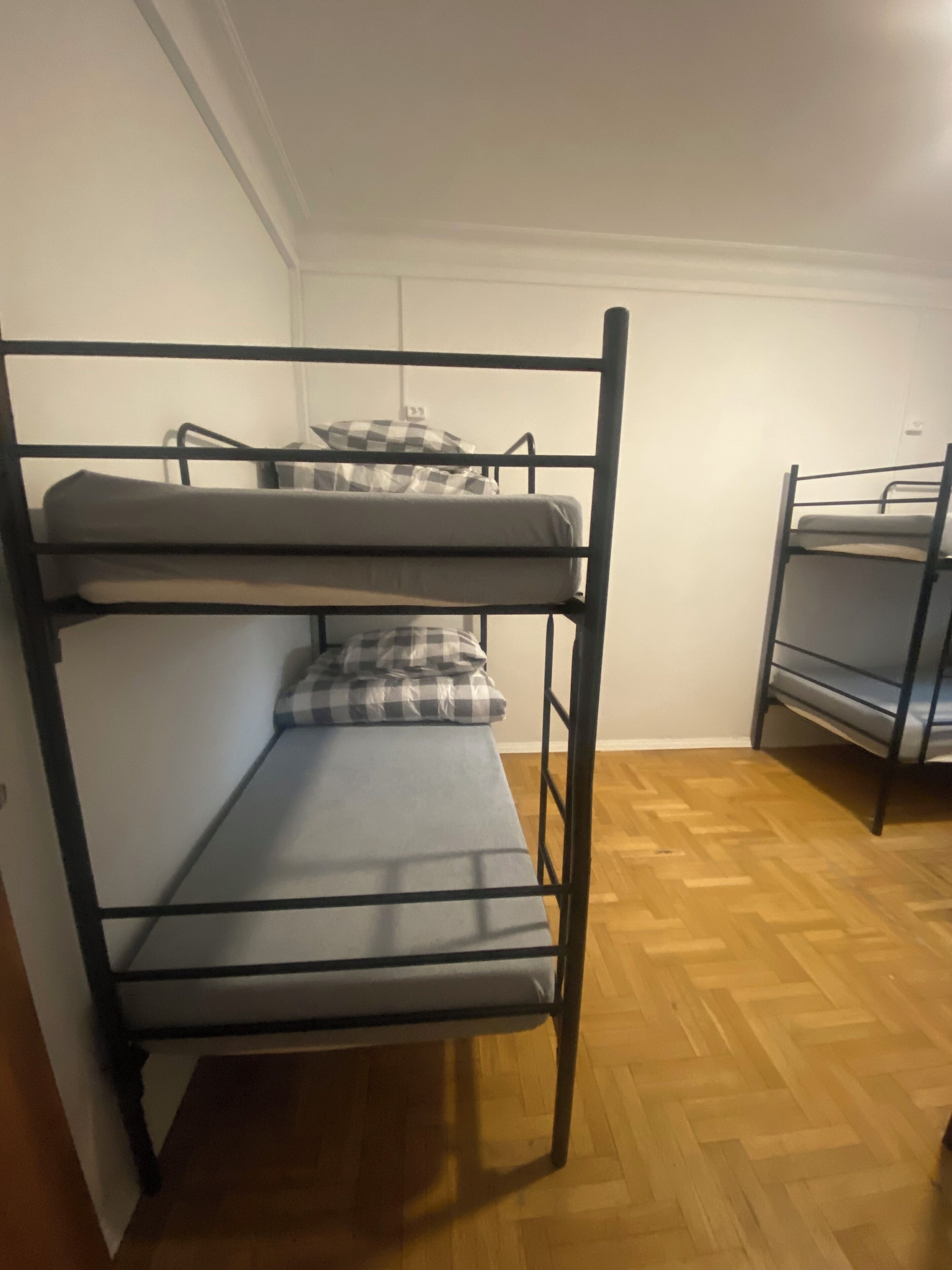 A bunk bed room with a wooden floor and white walls.
